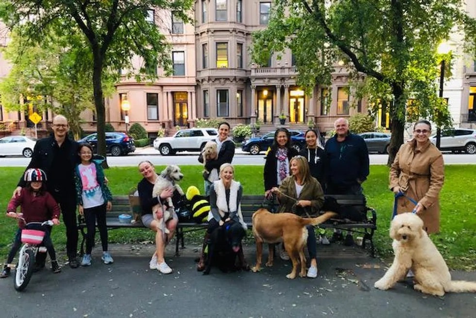 Image of a group of people and dogs on a bench in Boston celebrating Woodrow's fifteenth birthday
