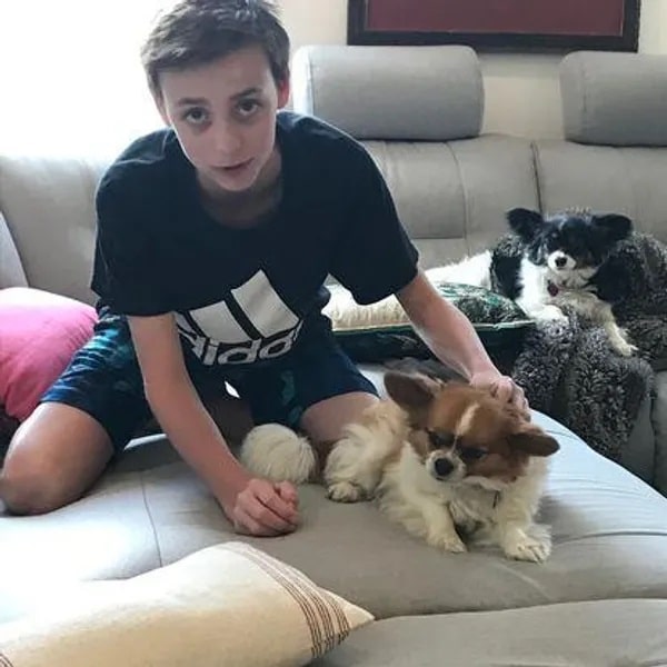 Image of Ethan, sitting on a couch with Henry and Lucy.