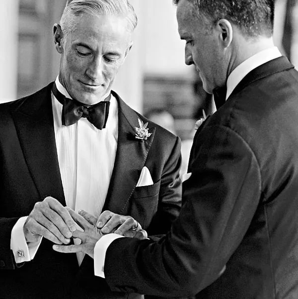 Image of Stephen placing a wedding ring on Rufus' finger